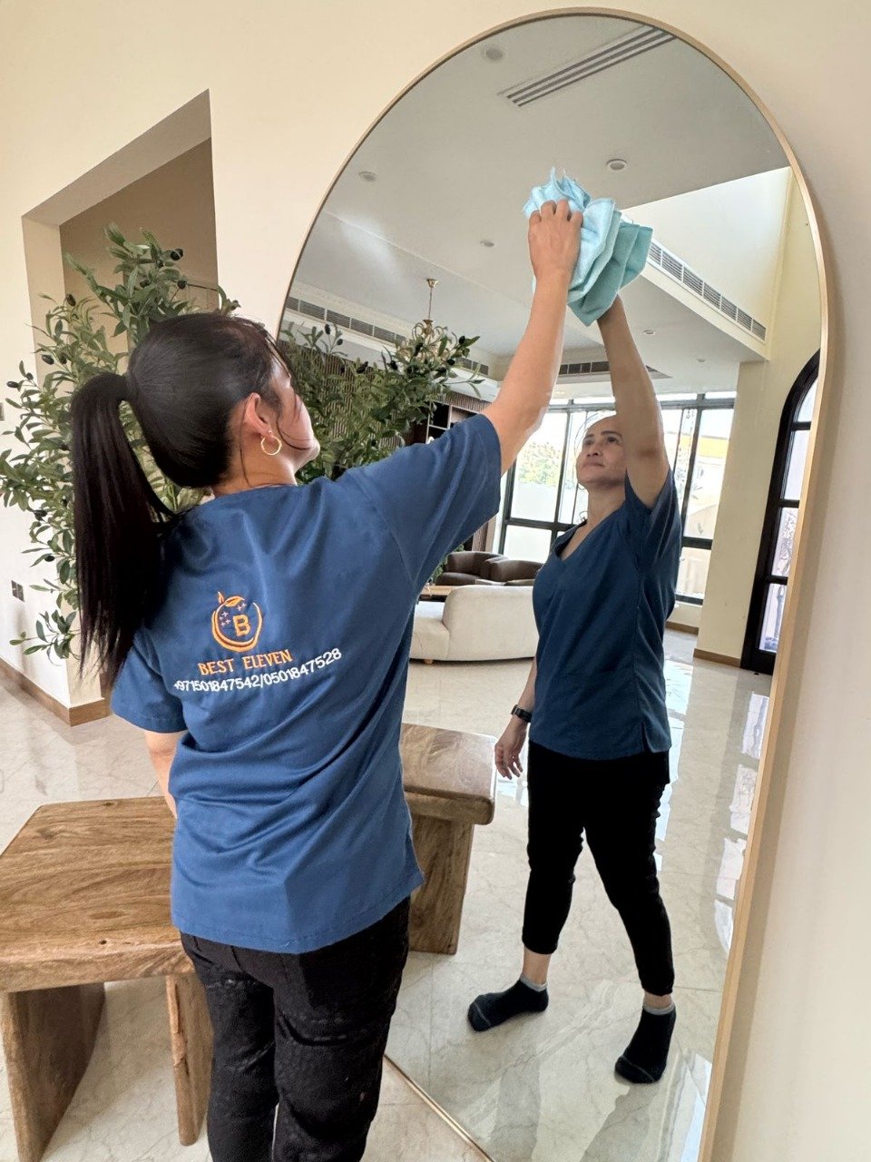 Woman wiping a glass surface with a cleaning cloth