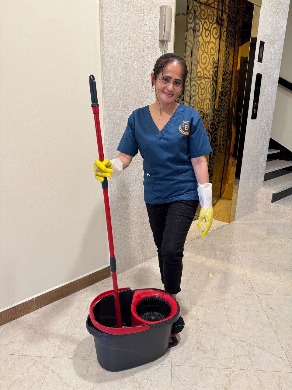 Smiling woman holding a mop ready for cleaning