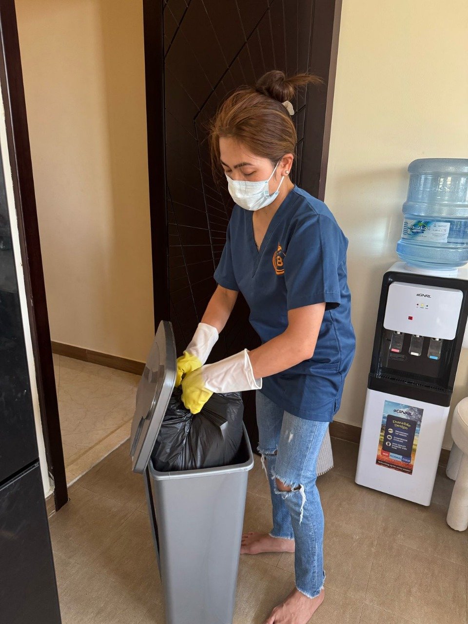 Woman throwing garbage into a dustbin