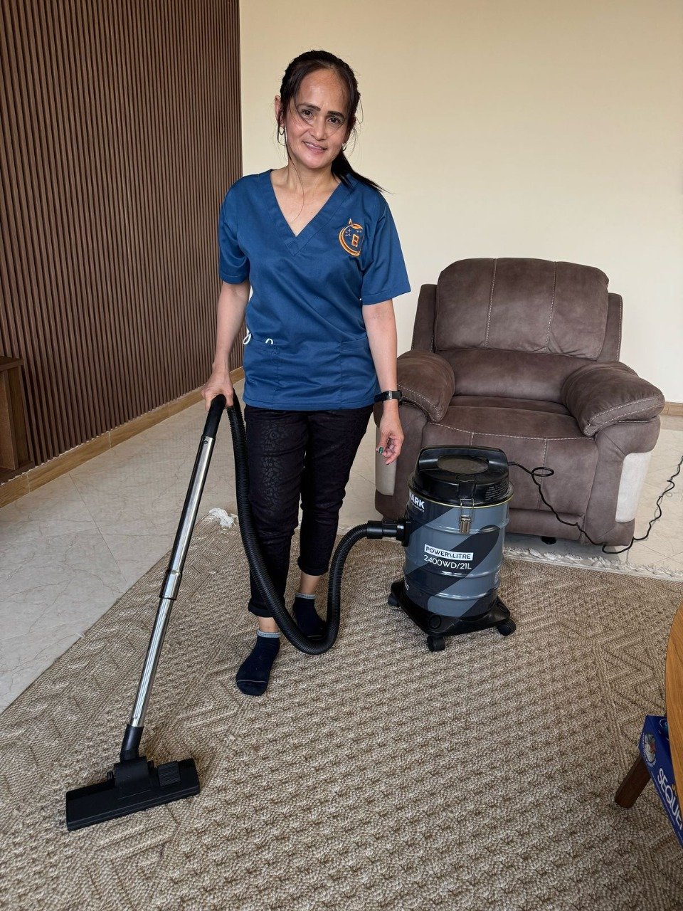 Woman vacuuming a carpet with a vacuum cleaner