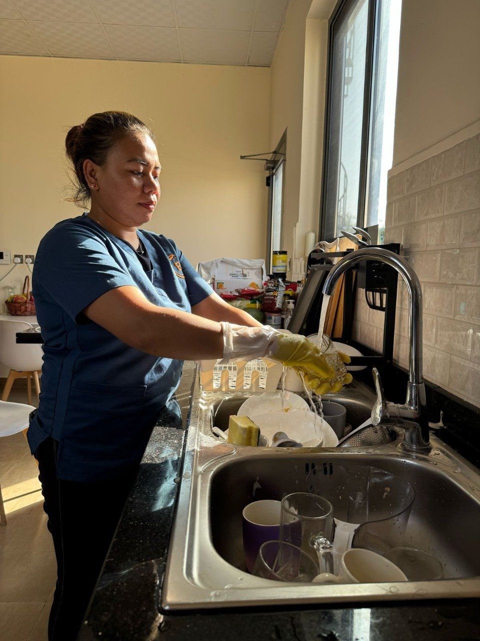 Woman washing dishes at a kitchen sink